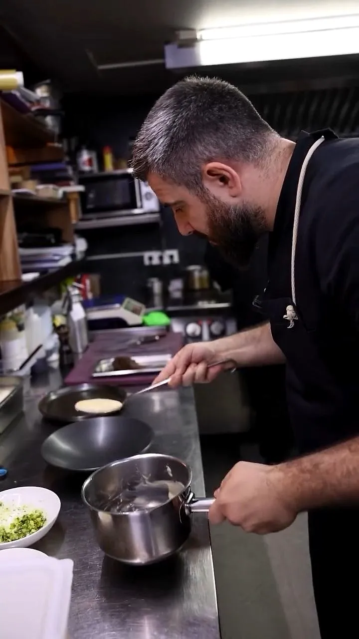 The head chef at the stove in the open kitchen