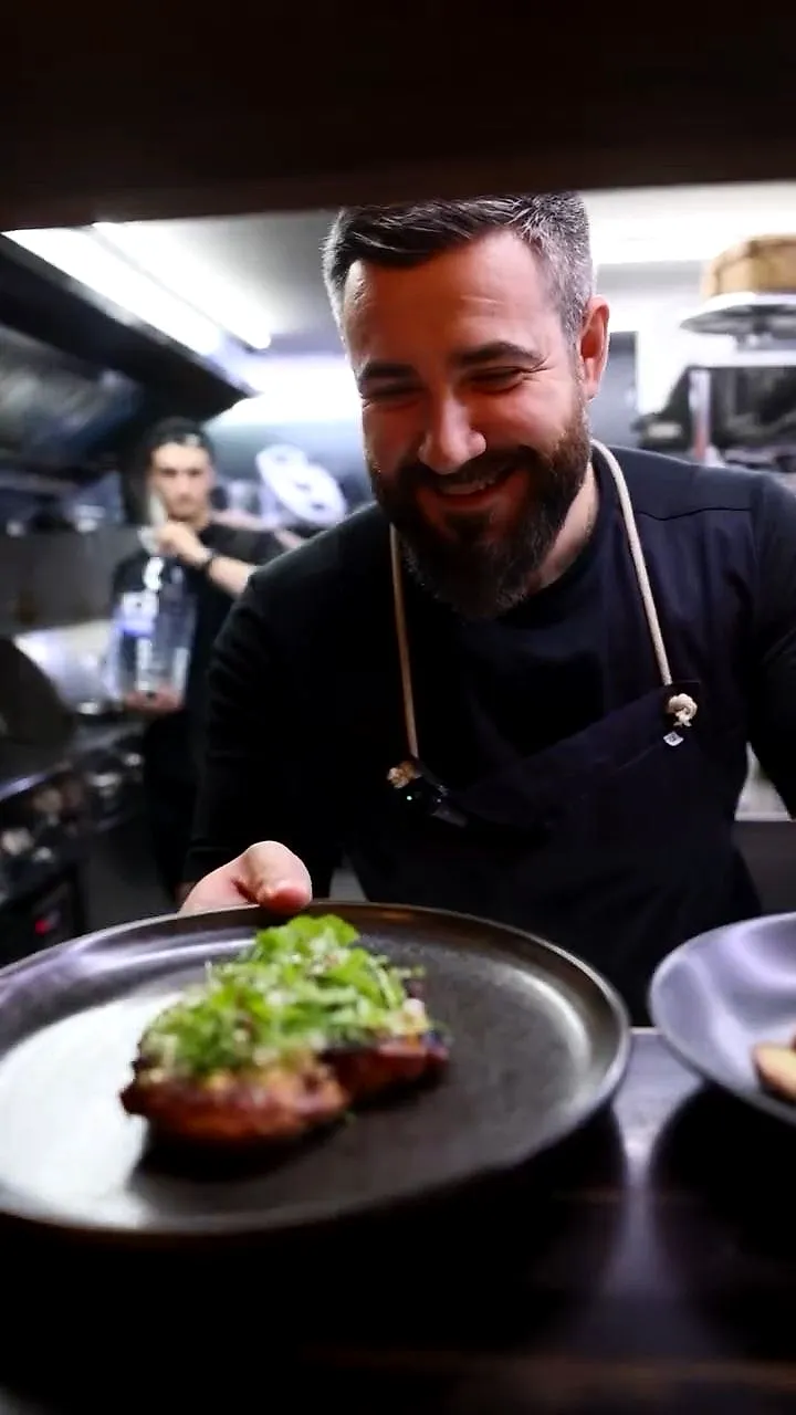 Bucătarul-șef Stanislav Osipenco, zâmbind lângă o farfurie în bucătărie